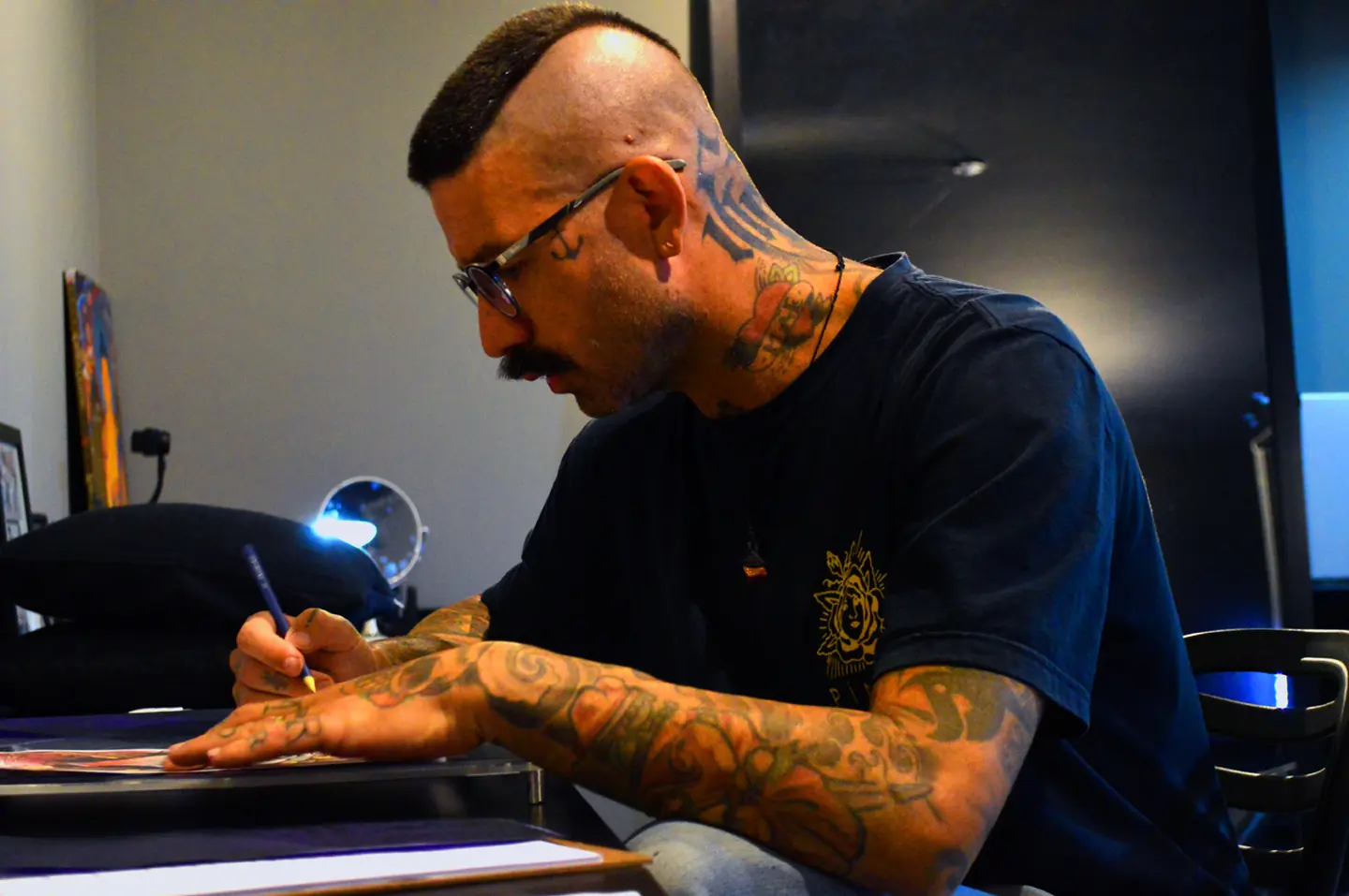 Márcio tatuando um cliente no estúdio em Ribeirão Preto
