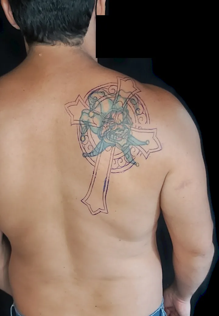 Tatuagem de cruz celta antiga e desbotada nas costas, antes da cobertura