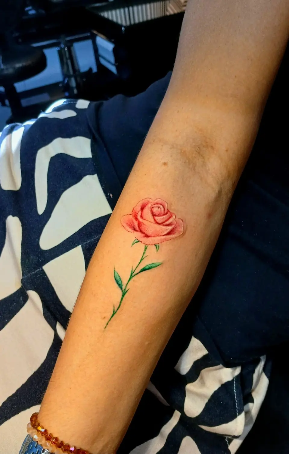 Rosa em traço fino e vermelho no antebraço