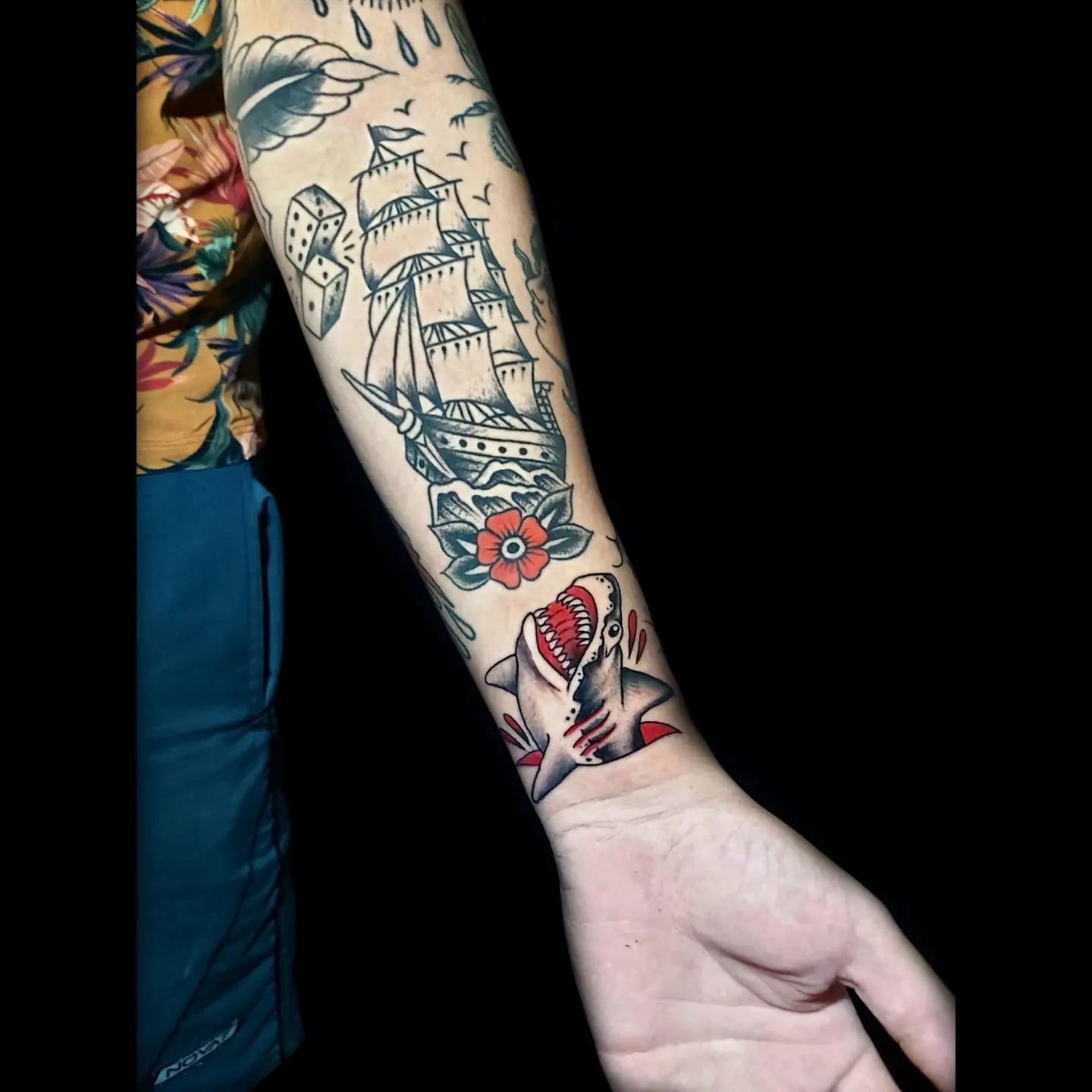 Braço fechado em old school colorido com navio e rosas